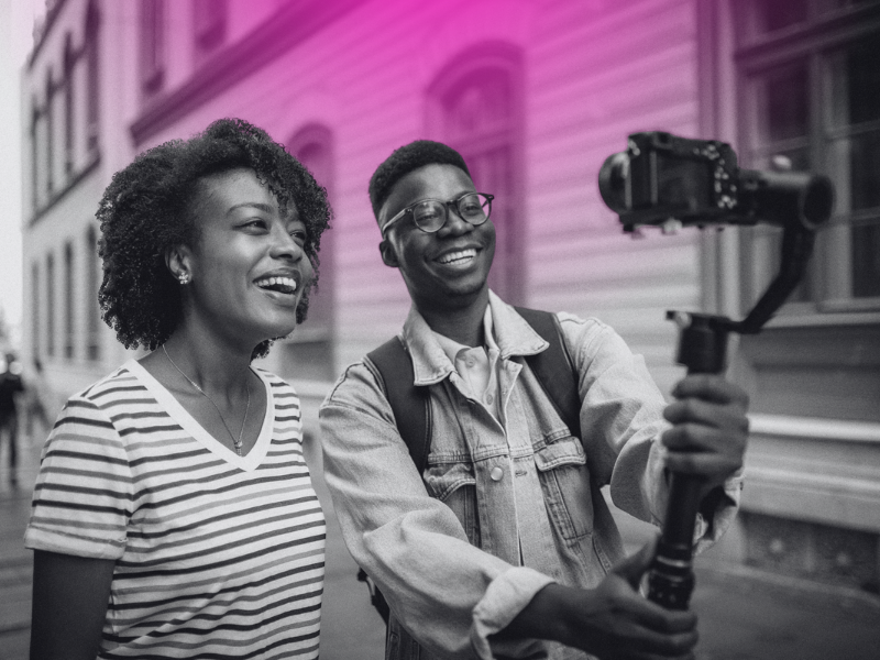 two people filming themselves with a camera on a gimble