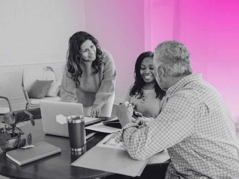 Happy people gathered around office table